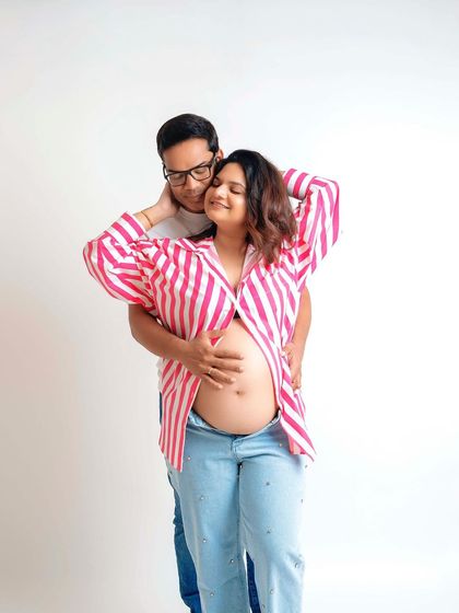 A happy and relaxed couple's portrait. The casual outfits and simple white background make their joy the center of attention.