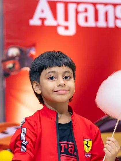 The birthday boy, Ayansh, posing with his cotton candy in front of the amazing car-themed party decor. We love matching our fun food to your theme.