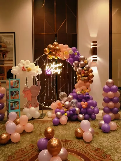 A closer look at the elephant-themed welcome baby backdrop with a neon sign and fairy lights.