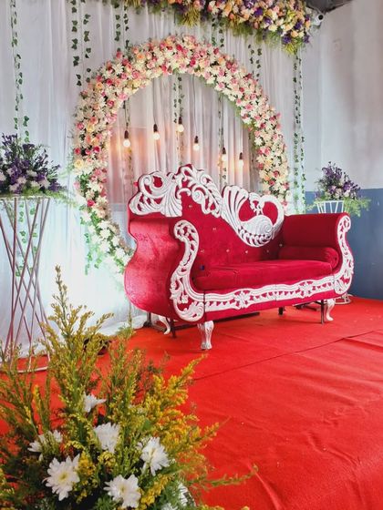 Another view of the floral stage decoration, showing the red carpet and the ornate sofa. This is a timeless look for any formal celebration.