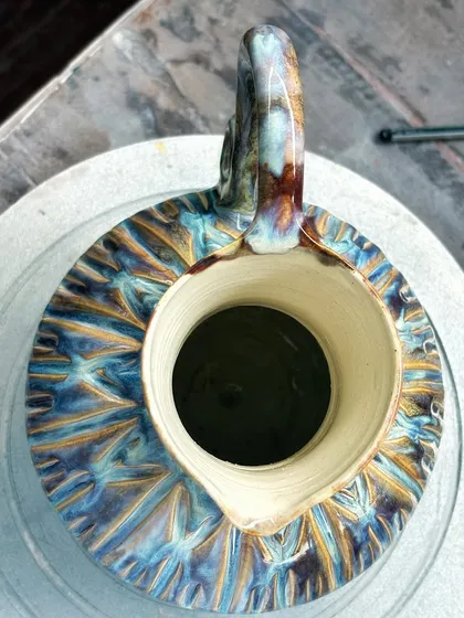 The colors on this pitcher make it one of my favorite pieces. The way the glazes melted and flowed in the kiln created these yummy flashes of blue, purple, and yellow. It’s pure kiln magic.