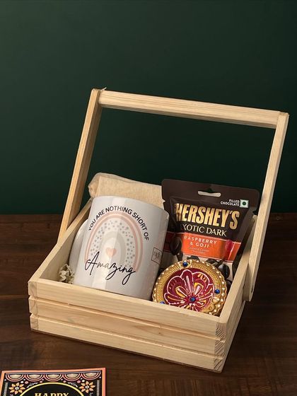 A still shot of the hamper from video 140, this wooden basket contains a motivational mug, Hershey's chocolate, and a decorative diya, perfect for employee appreciation.