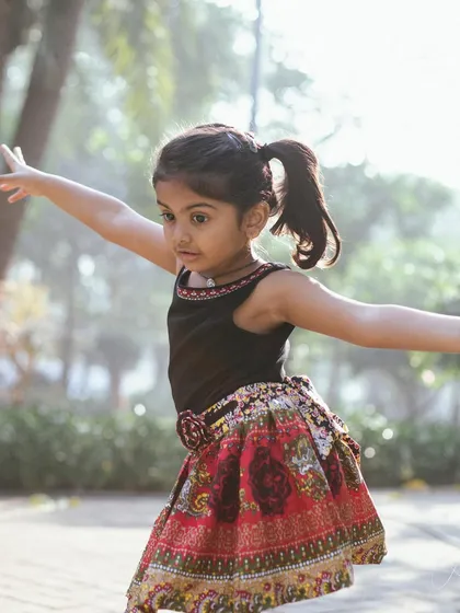 Arms outstretched, as if she's about to take flight. This photo captures her sense of freedom and imagination during her playful birthday session.