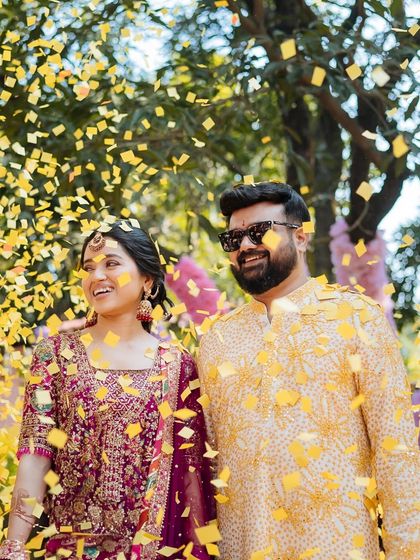 A joyful shot of the couple under a shower of yellow confetti, their smiles lighting up the frame.