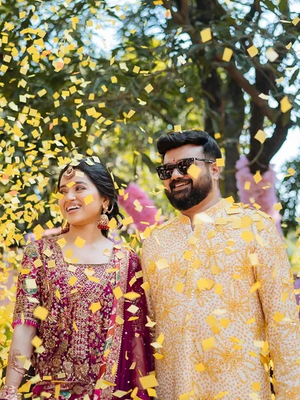 A joyful shot of the couple under a shower of yellow confetti, their smiles lighting up the frame.