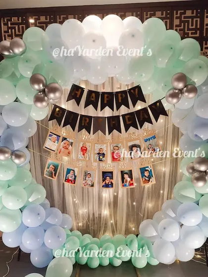 A balloon ring with a hanging photo garland, a beautiful way to display memories at a birthday party.