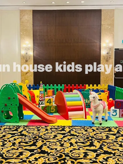 A side view of the rainbow play area, highlighting the rainbow bridge climber and plush ride-on toys.