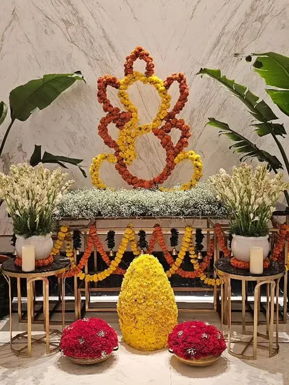 I create welcoming installations for corporate lobbies and entrances, like this elegant Ganesh decor for the Fairmont hotel. The design uses marigold flowers to form a traditional symbol, flanked by fresh plants and subtle lighting for a warm welcome.