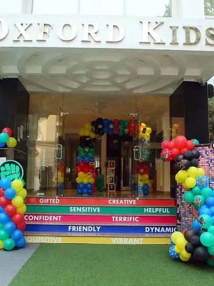 The Oxford Kids entrance decorated with superhero logos and colorful balloons.