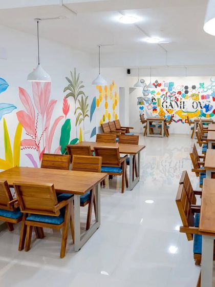 An overview of the Board Games Hub in Coimbatore, showing how the tropical and game-themed murals work together to create a cohesive and lively interior.