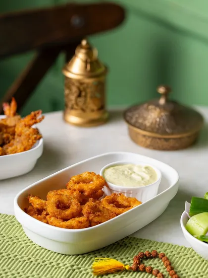 Fried calamari rings with a dipping sauce, part of a Ramadan special menu for The Big Chill Cafe UAE. The styling uses Middle Eastern-inspired props to set the theme.