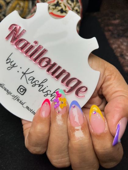 A playful and colorful set with multi-colored French tips and 3D floral accents.