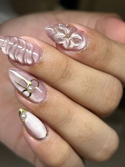 An elegant and intricate 3D nail art set. This design features sculpted transparent flowers, wavy textures, and delicate gold and pearl bow accents on a soft pink cat-eye base.