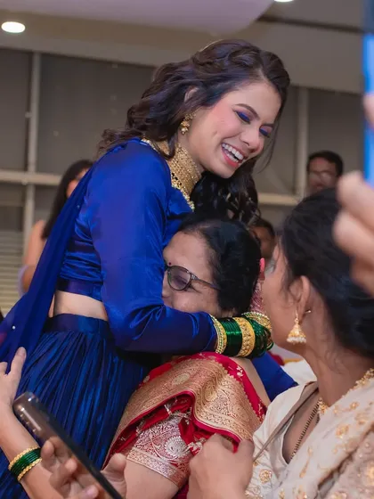 A candid moment of joy from a sangeet night. The bride's blue smokey eye and radiant smile light up the frame.
