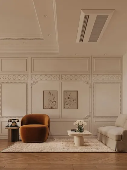 A cozy seating area within the bedroom, featuring a plush velvet armchair in a rich ochre hue. The wall paneling and herringbone wood floors provide a classic, textural foundation for the room's modern and vintage elements.