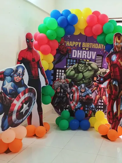 We assembled the ultimate Avengers party for a young superhero fan. This setup features life-sized cutouts of Iron Man, Captain America, and Spider-Man against a vibrant balloon arch and a custom city backdrop.