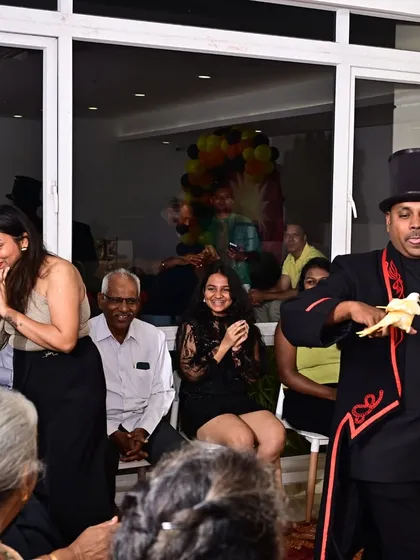The look of surprise is what I live for. Here, I'm performing my signature live pigeon trick for an audience of all ages at an intimate party setting.