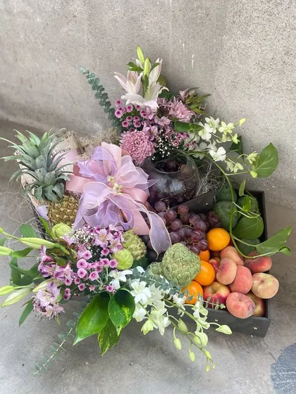 A bountiful fresh fruit hamper, elegantly arranged with an assortment of seasonal fruits and accented with delicate purple and white flowers. This is a healthy and beautiful gift option for any occasion.