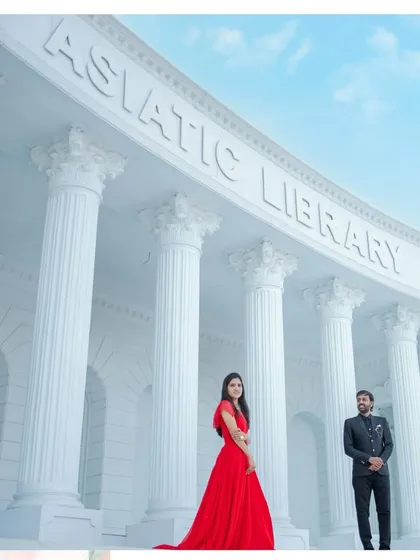 A low-angle shot that emphasizes the grand scale of the studio architecture, with the couple looking like stars in their own movie.