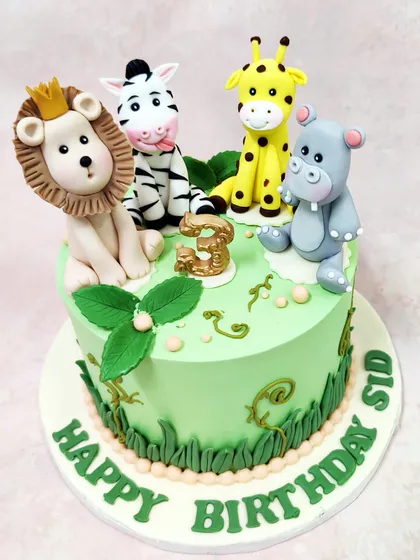 Another angle of our animal jungle theme cake, showing the intricate grass and vine details on the side.