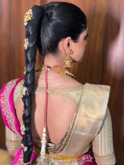 A side view of the high ponytail braid, showing how the traditional hair accessories are secured and how the braid falls cleanly down the back.