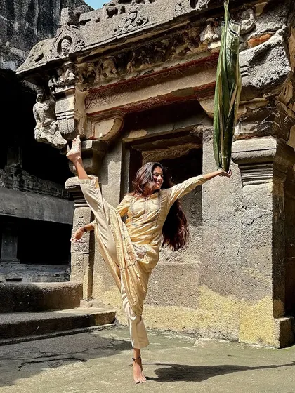 A display of flexibility and grace, combining dance and yoga in the sacred space of the Ellora Caves.