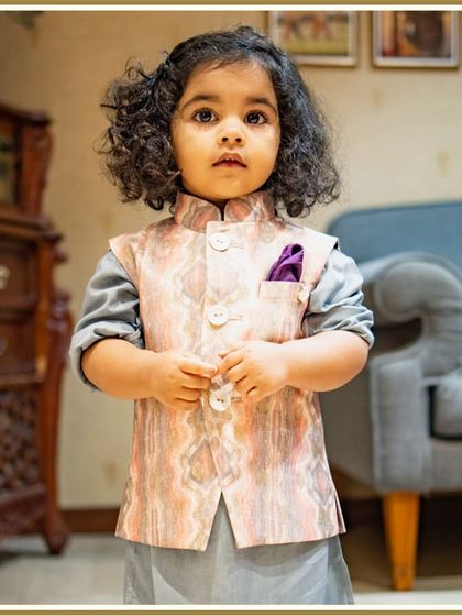 A close-up of our little client looking thoughtful and dapper in his printed Bundi set. The soft curls and serious expression are just too cute.