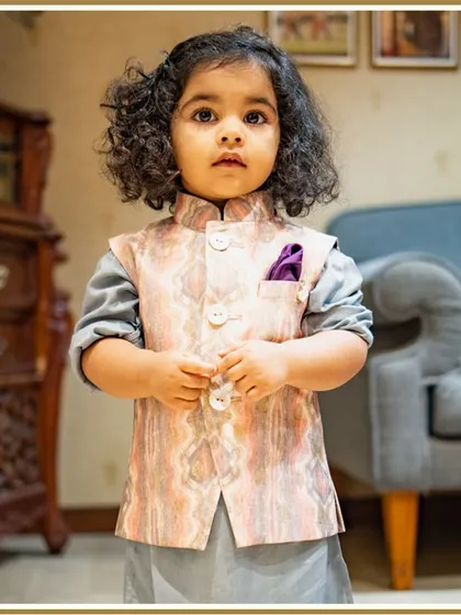 A close-up of our little client looking thoughtful and dapper in his printed Bundi set. The soft curls and serious expression are just too cute.