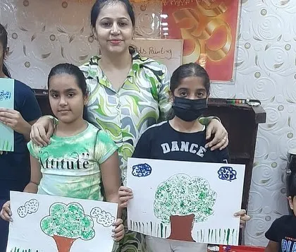 A smaller group of students with their tree paintings. I make sure to give personal attention so each child can develop their skills at their own pace.