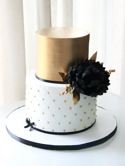 A bold and beautiful cake for a 50th birthday celebration. I paired a quilted white fondant tier with a metallic gold top tier, accented with a dramatic handmade black sugar flower.