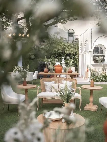 A candid view of the lounge seating at the 'Oasis of Love' event, showing a mix of cane and upholstered furniture for a relaxed yet refined feel.