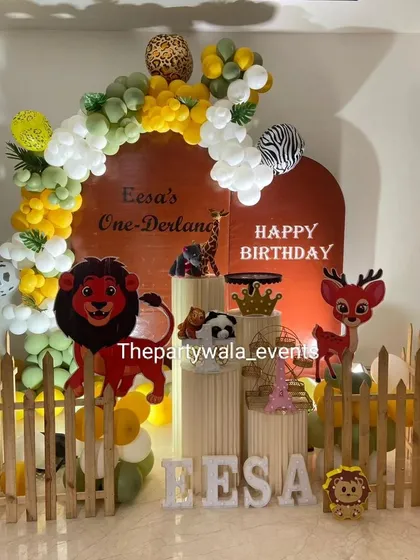 A "One-Derland" jungle theme with a unique terracotta-colored backdrop. The yellow, white, and green balloons complement the earthy tones perfectly.