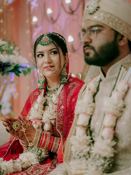 A candid shot of the couple during the ceremony. The bride's glance towards her guests shows a moment of connection amidst the rituals.