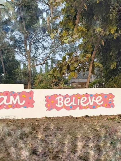 A simple and colorful "Dream Believe Achieve" mural, perfect for brightening up an outdoor school wall.