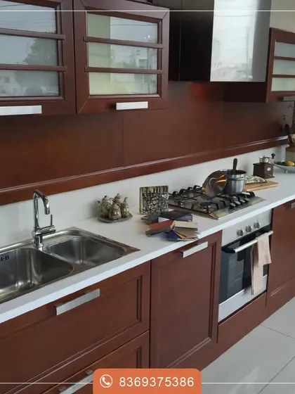 A wooden finish brings natural warmth and timeless sophistication to any kitchen. This design showcases the beauty of a rich wood grain, paired with a clean white countertop and modern hardware for a sleek, polished look.