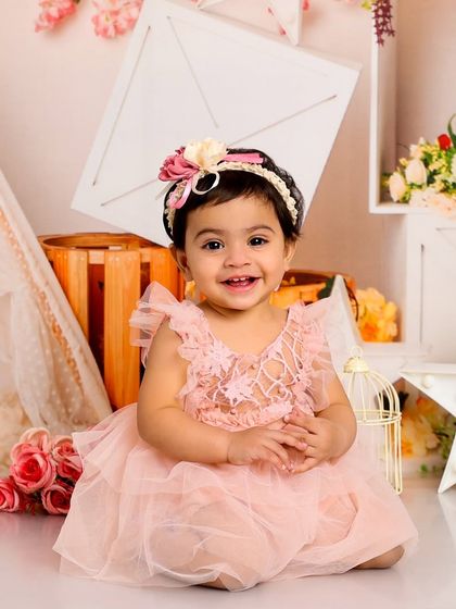 A sweet and gentle smile. This classic portrait in our floral-themed setup is the picture of innocence and happiness.