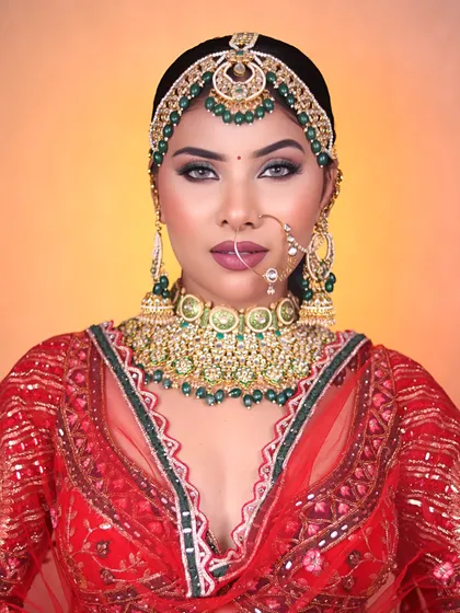This stunning look with green eyeshadow and a bold lip was created in our bridal makeup class. We teach students how to play with color to complement bridal outfits.