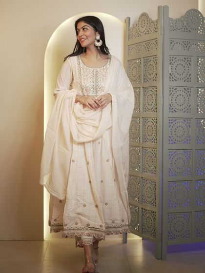 An off-white anarkali suit that is the epitome of grace. This is a versatile piece that can be dressed up or down for day or night functions.