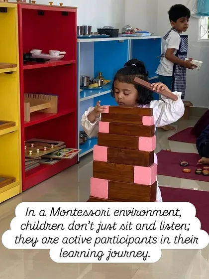 In our classroom, children are not passive listeners; they are active participants in their own education. Here, a child builds the Broad Stair, an activity that develops coordination and an understanding of dimension, all through hands-on work.