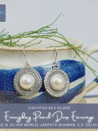 Simple yet elegant, these everyday pearl drop earrings feature a single pearl set in a granulated silver disc. They are perfect for both office wear and casual outings.
