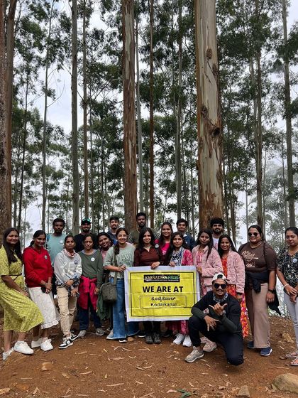 Our Kodaikanal group posing with our banner in the pine forest.