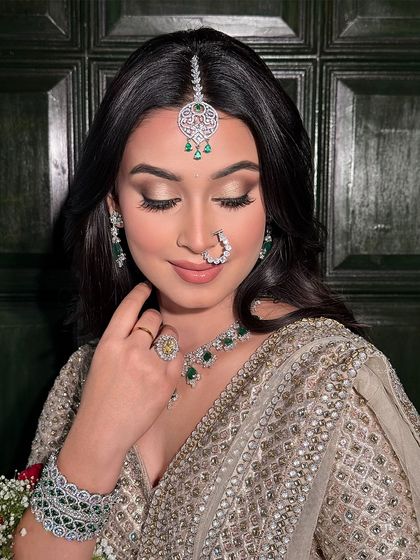 A beautiful soft glam look perfect for a wedding guest. The focus is on flawless skin and softly defined eyes, complemented by stunning emerald and diamond jewellery.