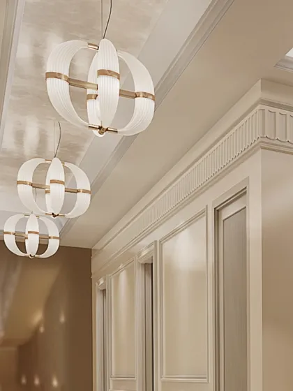 A detail of the lighting in the bar area, showing the contrast between the modern spherical pendants and the classic wall moldings. This layering of styles creates a unique and sophisticated space.