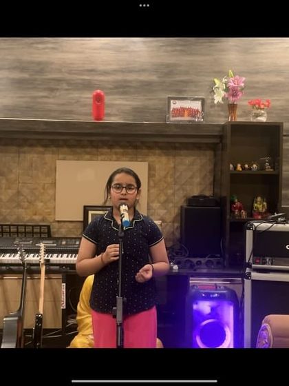 Alish in her element, surrounded by musical instruments. Our holistic approach encourages children to pursue their passions with confidence and dedication.