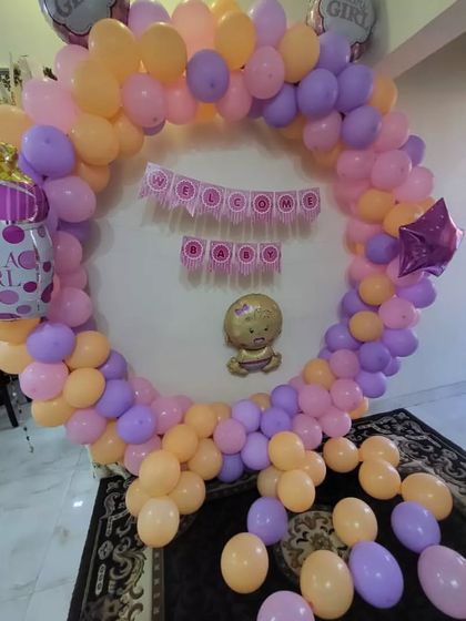 Another angle of the "It's a Girl" baby shower setup. This view shows the full circular balloon arch with the cute baby girl foil balloon in the center, ready for photos and celebration.