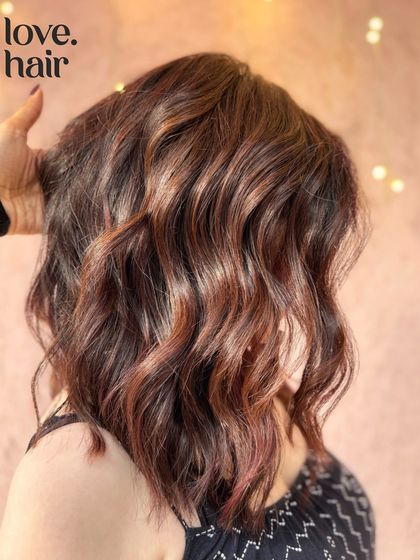 A close-up of the mellow mahogany balayage, highlighting the blend of red and brown tones and the soft, wavy texture.