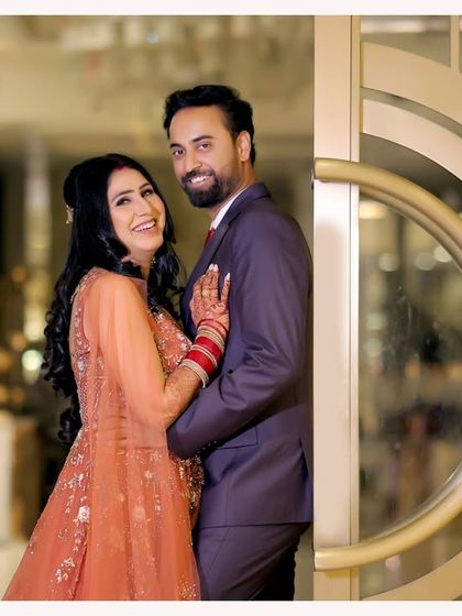 A joyful and classic couple portrait from their reception. Their happy smiles and comfortable embrace in front of an elegant doorway make for a perfect, timeless memory.