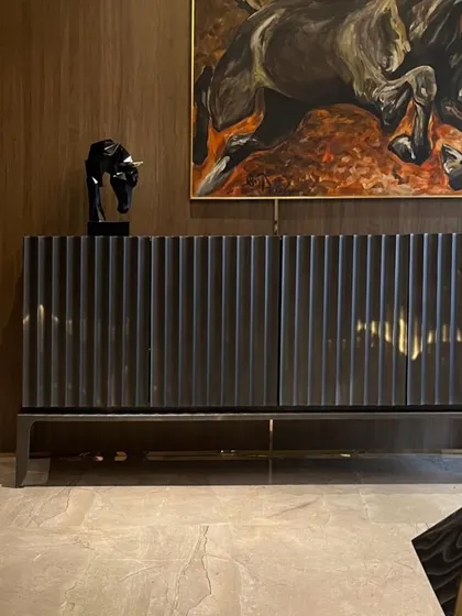 Art and furniture are integrated to tell a story. This fluted console, paired with a powerful piece of art and a sculptural object, creates a curated focal point within the home.