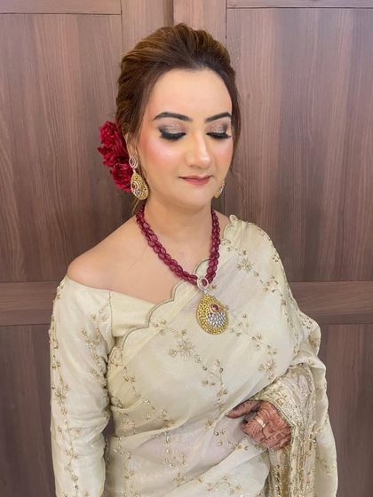 A classic Indian wedding guest look. The traditional bun is adorned with fresh flowers, and the makeup is kept elegant and timeless.