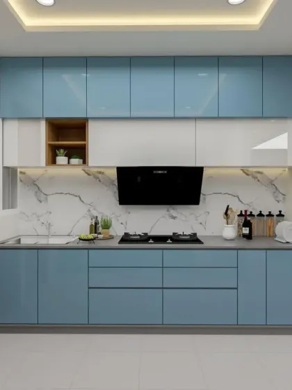 A straight-line modular kitchen in a beautiful shade of blue. The design features a marble backsplash and a built-in chimney, making it perfect for apartments.